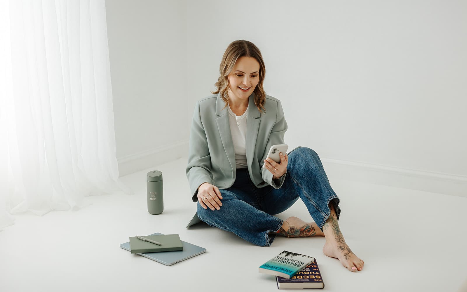 Marissa Esposito seated with a notebook, tablet, and leadership books, representing confidence habits for women in construction.